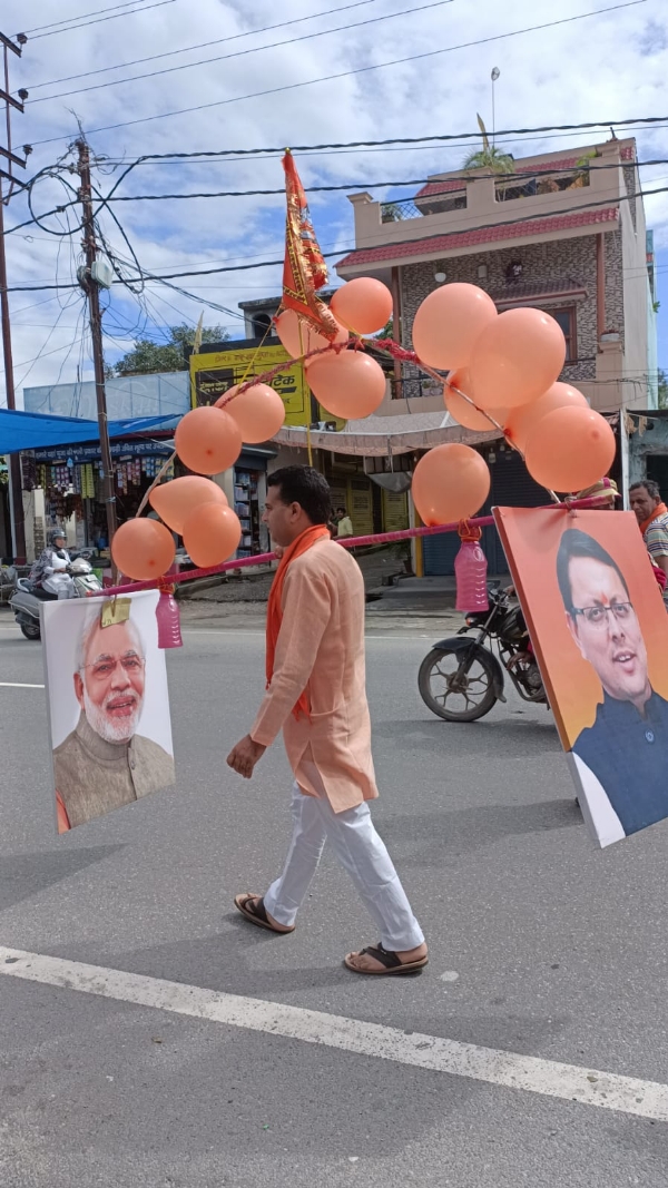 देहरादून:  कांवड़ के मौसम में कांवड़िये राजनेताओं की तस्वीरों का प्रयोग करने से भी कोई परहेज नहीं करते हैं। जहां अन्य कांवड़िये अपनी कांवड़ में मोदी-योगी के चित्र लगाकर चल रहे हैं वहीं भाजपा के प्रवक्ता नवीन ठाकुर की कांवड़ में मोदी और धामी के चित्र भी आकर्षण का केन्द्र रहे।  मंगलवार को सावन की शिवरात्रि के पावन अवसर पर ब्रह्ममुहूर्त में किये जाने वाले हरिद्वार गंगा स्नान के लिये सोमवार शाम को सहसपुर के महादेव प्राचीन शिव मंदिर से शिव भक्तों का एक दल हरिद्वार के लिये रवाना हुआ। इसकी अगुवाई भाजपा के प्रदेश प्रवक्ता नवीन ठाकुर ने की।  सहसपुर के स्थानीय लोगों ने धूमधाम के साथ सहसपुर बाजार में महिलाओं की शोभायात्रा निकालते हुए शिवभक्तों को हरिद्वार के लिये रवाना किया। इसके बाद मंगलवार को कांवड़ लेकर लौटी यात्रा का स्थानीय लोगों ने महादेव प्राचीन शिव मंदिर सहसपुर में स्वागत किया।  इस दौरान प्रधानमंत्री नरेंद्र मोदी और मुख्य मंत्री पुष्कर सिंह धामी के तस्वीर लगी नवीन ठाकुर की कांवड़ झांकी हरिद्वार से लेकर सहसपुर तक आकर्षण का केंद्र रही। इस दौरान युवाओं ने नवीन ठाकुर की मोदी -धामी की कांवड़ झांकी के साथ जगह-जगह सेल्फी ली। नवीन ठाकुर ने बताया कि इस वर्ष की कांवड़ यात्रा पूरे देश में इतिहास रचने जा रही है। उत्तराखंड और उत्तरप्रदेश के मुख्यमंत्री पुष्कर सिंह धामी और योगी आदित्य नाथ के नेतृत्व में कांवड़ का शानदार आयोजन किया जा रहा है। राज्य सरकार का तमाम प्रशासनिक अमला कांवड़ यात्रा की व्यवस्थाओं में जुटा रहा।  उन्होंने कहा कि उत्तराखंड के मुख्यमंत्री पुष्कर सिंह धामी ने कांवड़ यात्रियों का स्वागत चरण धोकर और हेलीकॉप्टर से कावड़ियों पर पुष्प वर्षा कर सबका दिल जीत लिया है। यह लाखों करोड़ों शिव श्रद्धालुओं के लिये एक सुखद एहसास है। उन्होंने कहा कि प्रधानमंत्री मोदी के कारण आज देश ही नहीं पूरे विश्व में सनातन धर्म और भारत का दबदबा कायम हो रहा है। दूसरी तरफ राजस्थान में कांग्रेसी सरकार ने कांवड़ियों पर प्रतिबंध लगा रखा है। गाना-बजाना आदि को प्रतिबंधित किया गया है।  इस दौरान सुनील गुप्ता, सिद्धार्थ चौधरी, संदीप अंतिल, कलीराम सकलानी, अनिल कुमार, सूरज रावत, सचिन पंवार आदि लोग शामिल रहे।